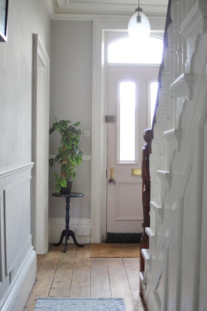 Victorian hallway with original floorboards, wall panelling and pink front door from Life with Holly