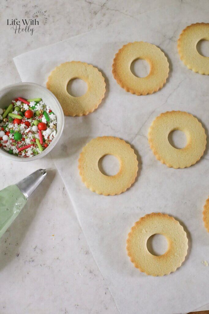 Festive Christmas Wreath Cookies - buttery sugar cookies decorated with royal icing wreaths and sprinkles for easy Christmas treats.