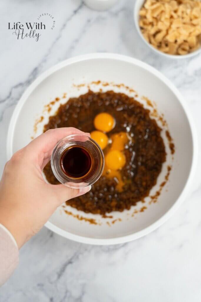 Adding eggs and vanilla to make cookies